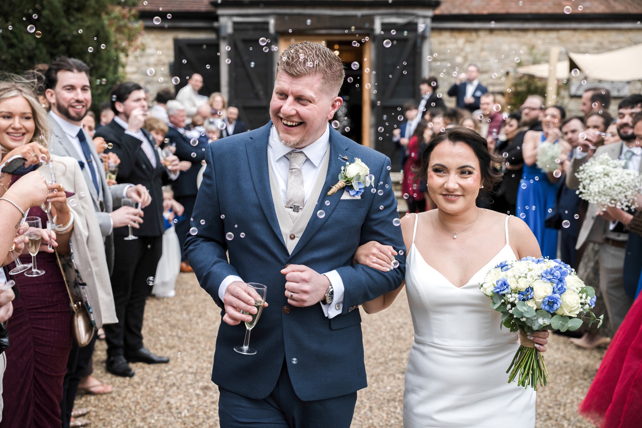 Bride and groom walking through bubble exit at Notley Tythe Barn