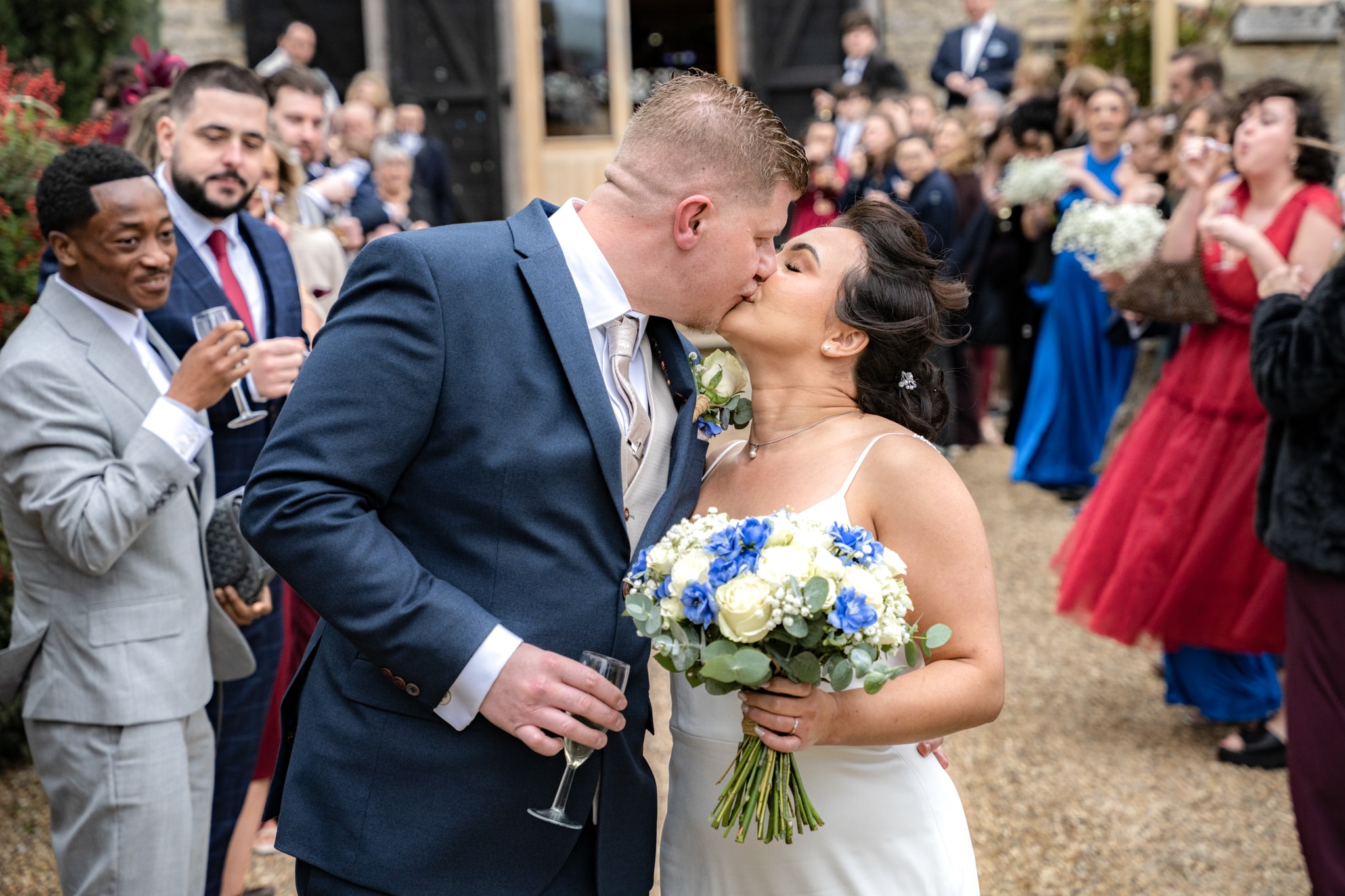 Bride and groom kissing during bubble exit at Notley Tythe Barn