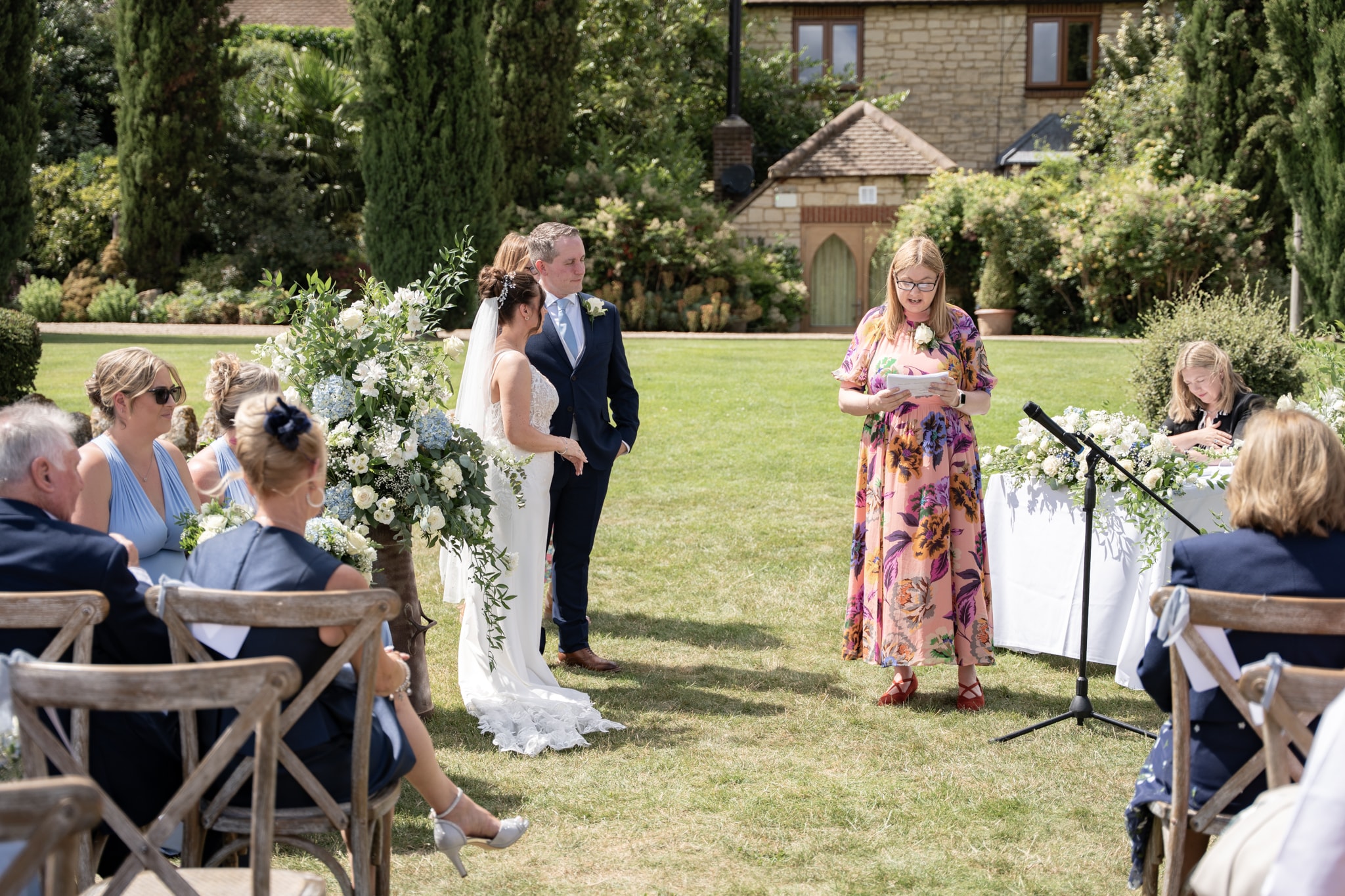 Outdoor wedding ceremony with officiant reading at Notley Tythe Barn garden
