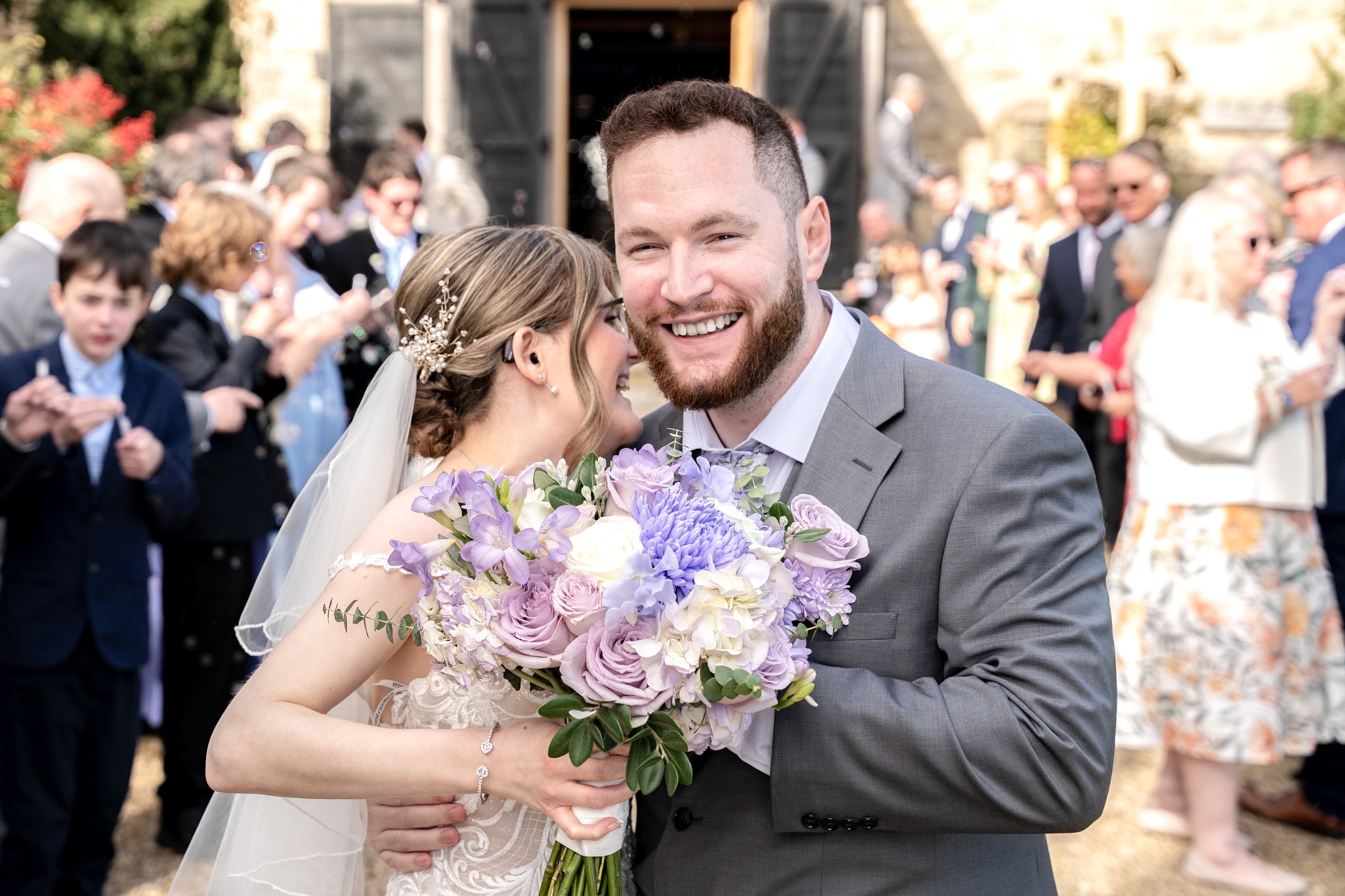 Bride and groom smiling together with bouquet after ceremony at Notley Tythe Barn